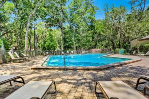 a swimming pool in a yard with tables and chairs at Hotel Side Condo at Amelia Island Plantation with Balcony, WiFi & Shared Pool in Fernandina Beach +15 photos