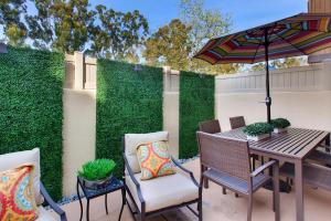 a patio with a table and chairs and an umbrella at On the Doorstep in Anaheim