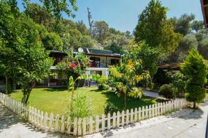 a house with a fence in front of a yard at Lagoon Boutique Oludeniz in Fethiye