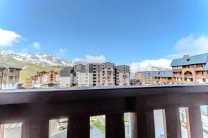 葱仁谷Central Val Thorens - Cozy 1BR Apartment Right on Slopes的城市建筑与山脉景观