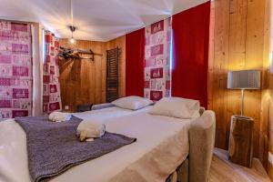 葱仁谷Central Val Thorens - Cozy 1BR Apartment Right on Slopes的红色墙壁客房的两张床