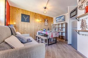 葱仁谷Central Val Thorens - Cozy 1BR Apartment Right on Slopes的客厅里有一张沙发和一张桌子。