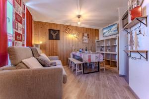 葱仁谷Central Val Thorens - Cozy 1BR Apartment Right on Slopes的客厅里有一张沙发和一张桌子。