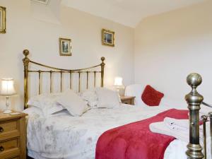a bedroom with a large bed with a red blanket at White Hill Farm Cottage in Dingestow +13 photos