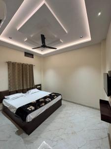 a bedroom with a bed and a ceiling fan at Hotel Shree Balaji in Ujjain