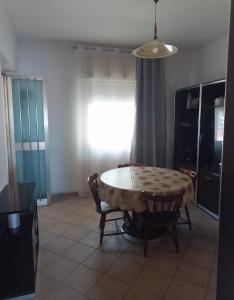 Un comedor con mesa y sillas y una ventana. en Villa Conchiglia, en Butera