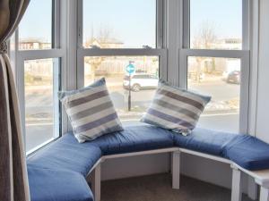 eine Bank vor einem Fenster mit zwei Kissen in der Unterkunft Coastguard Cottage in Ryde + 14 Fotos