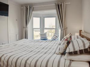 ein Schlafzimmer mit einem großen Bett mit Fenster in der Unterkunft Coastguard Cottage in Ryde