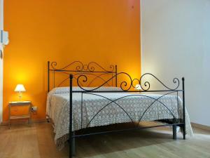 ein Schlafzimmer mit einem Bett mit einer orangefarbenen Wand in der Unterkunft Il Piccolo Baglio in Valderice