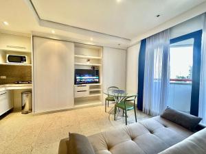a living room with a couch and a table at Bienal Suites Ibirapuera c/ Sacada - UH 1207 in São Paulo