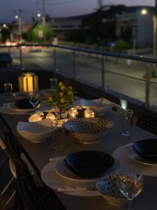 a table with candles and plates and bowls on a bridge at Aelio Suites- Near Airport and Beach in Markopoulo