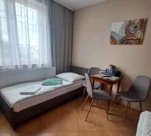 a small room with a bed and a table at Przystań Biskupińska in Biskupin