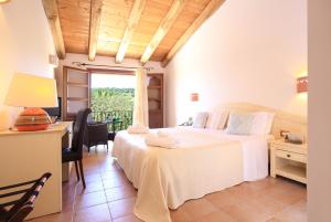 a bedroom with a bed and a desk and a window at Alghero Resort Country Hotel & Spa in Alghero