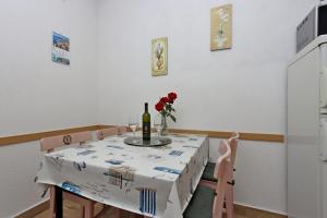 a dining room table with a bottle of wine and flowers at Apartments by the sea Punat, Krk - 19831 in Punat +11 photos