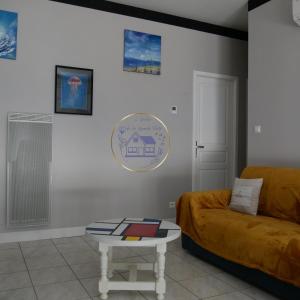 a living room with a couch and a table at L'Enclos de La Grande Flûte 