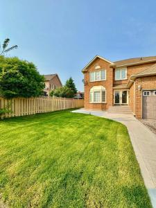 een stenen huis met een hek en een tuin bij 2 BR Private Basement Suite | Minutes from YYZ in Brampton