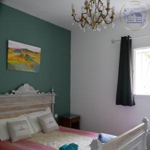 a bedroom with a bed and a chandelier at L'Enclos de La Grande Flûte  +13 photos