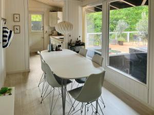 a kitchen with a white table and chairs and a window at Cozy Family Holiday Home By Nordstrand in Nykøbing Sjælland +16 photos