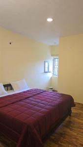 a bedroom with a large bed with a red blanket at Leo Home Stay - Suite Rooms Best For Family-Group-Couple-Single in Kodaikānāl