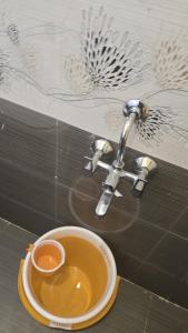 a cup of coffee sitting on a plate next to a sink at Leo Home Stay - Suite Rooms Best For Family-Group-Couple-Single in Kodaikānāl
