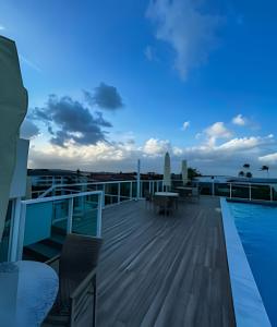 a deck with a view of the ocean at dusk at Flat Piscina Privativa 90 MT Praia centro in Porto De Galinhas +60 photos