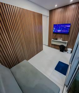 an empty room with a tv on a wooden wall at Flat Piscina Privativa 90 MT Praia centro in Porto De Galinhas