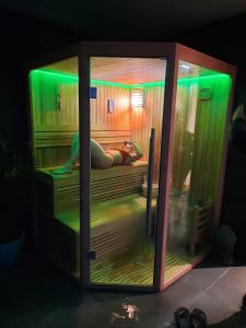 a person laying on a bed in a room with green lights at Fragas do Cabril Eco & Wellness Lodge in Lousã