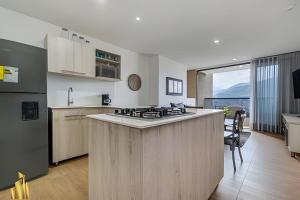 a kitchen with a stove top island in a room at Class 48 apto. 1303 - Luminoso / Vistas / Balcón in Sabaneta
