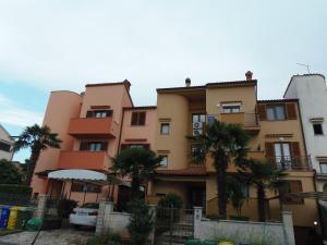 un edificio con palmeras delante en Apartments Novak en Rovinj