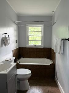 a bathroom with a tub and a toilet and a sink at Stylish Stay on Elizabeth-near to Cafes and Music in Lafayette +1 photo