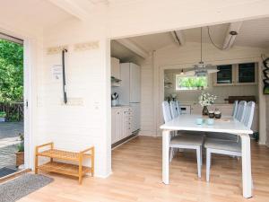 a kitchen and dining room with a white table and chairs at 4 star holiday home in Hejls in Hejls +28 photos