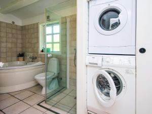 a bathroom with a washing machine and a toilet at 4 star holiday home in Hejls in Hejls