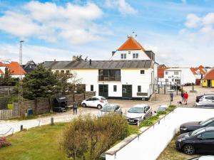 een wit huis met auto's geparkeerd op een parkeerplaats bij 5 star holiday home in Løkken in Løkken