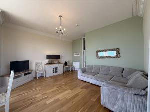 Una sala de estar con un sofá y un televisor. en Ocean View, en Seaton