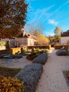 a garden with bushes and a building and a tree at Domaine la valette in Thollet
