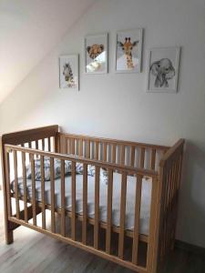 a crib in a room with four pictures on the wall at Ferienhaus Kribbikrabba Butjadingen in Butjadingen