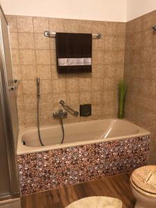 a bathroom with a bath tub with a toilet at Ferienhaus Kribbikrabba Butjadingen in Butjadingen +28 photos