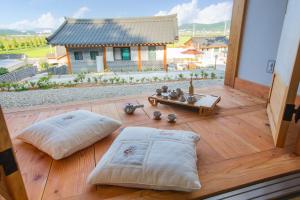 a room with two pillows on a wooden floor at Suncheon Suncheon Bay forest pension in Suncheon