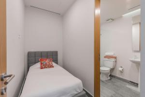 a small bedroom with a bed and a toilet at Luxurious 4BR condo by the beach - Rooftop pool in Cancún +18 photos