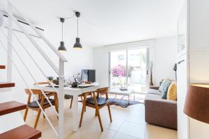 a white living room with a table and chairs at Casa Molinar in Palma de Mallorca