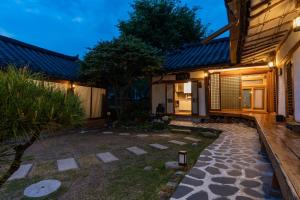 a garden in front of a house at night at Yangpyeong Baknyeon gotack Yusunjae Hanok pension in Yangpyeong