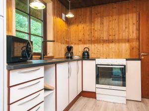 une cuisine avec des armoires blanches et une cuisinière dans l'établissement 6 person holiday home in Blåvand, à Blåvand 28 autres photos