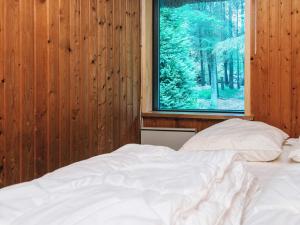 une chambre avec un lit blanc et une fenêtre dans l'établissement 6 person holiday home in Blåvand, à Blåvand