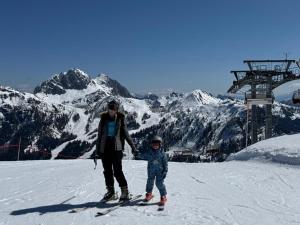 a man and a child standing on a ski slope at River Pearl - Garnitzenklamm in Möderndorf