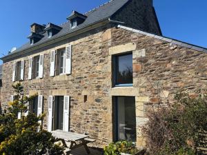een stenen huis met een bankje ervoor bij Ti Yoco in Ploubazlanec