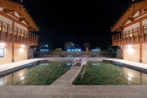 a swimming pool in the middle of a building at night at Hanok Pension Wanggyeong in Gyeongju