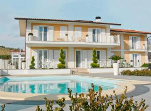 a house with a swimming pool in front of it at Residenza delle Grazie in Cossignano