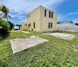 a house with a palm tree in front of it at Nice and Cozy House in the Greater Ponce Area in Ponce