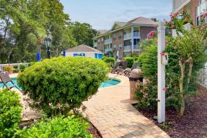 a courtyard with a pool and some bushes and a building at Gardens at Cypress Bay 19-104 in Little River