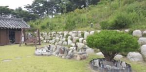 un mucchio di rocce in un cortile con una panchina di Gangneung Hakdong Hanok Pension a Gangneung